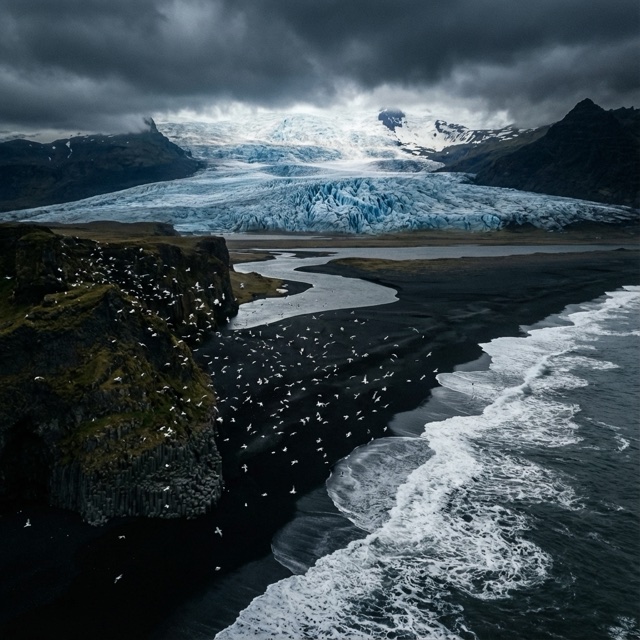 Test still of a glacier above a black beach and birds