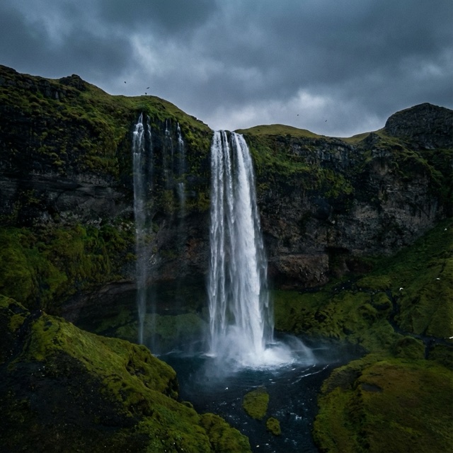 Test still of a tall waterfall between dark green cliffs